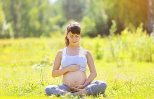 Pregnant beautiful woman yoga outdoors
