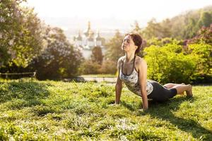 Young woman practicing yoga outdoors photo