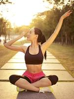 joven asiática practicando yoga al aire libre al atardecer