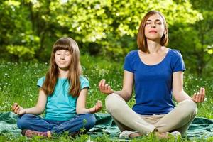 Mother and daughter meditating photo