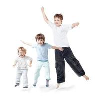 three children jump on white