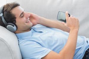 Cheerful man enjoying music with his smartphone