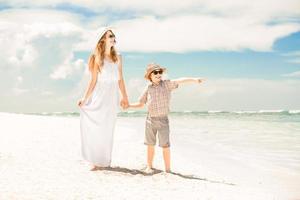 Happy beautiful mother and son enjoying beach time photo