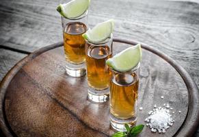 Glasses of tequila on the wooden board