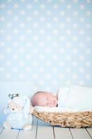 Picture of a newborn baby curled up sleeping in basket