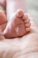 Innocent life  tiny baby foot in  palm of male hand