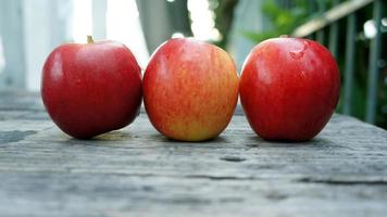 Three Red Apples on the wooden table photo