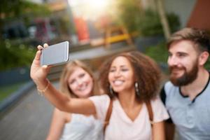 mujer joven tomando selfie con amigo