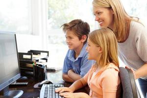 madre e hijos usando la computadora en casa foto