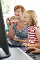 Female Elementary Pupil In Computer Class With Teacher photo