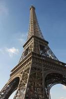 sunlit Eiffel Tower, Paris, against blue sky photo