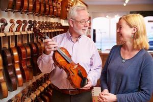 vendedor asesorando al cliente comprando violín