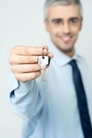 joven agente de bienes raíces que ofrece la llave de la casa