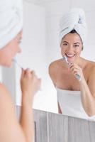 Mature woman brushing her teeth photo
