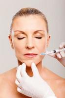 mature woman receiving lips injection photo