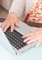 primer mano anciana usando laptop