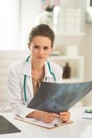 mujer médico con fluorografía en el consultorio