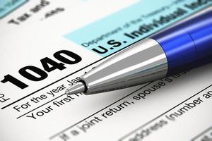 el formulario de impuestos de devolución individual 1040 y bolígrafo foto