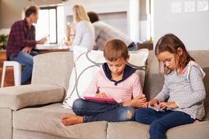 Kids playing with new technology while adults entertain photo