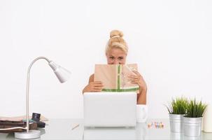 Happy Blonde girl at her workspace. Frontal view photo