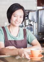 Smiling asian barista   posing with cup of coffee photo
