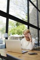 mujer de negocios hablar por teléfono inteligente mientras mira a la pantalla de net-book