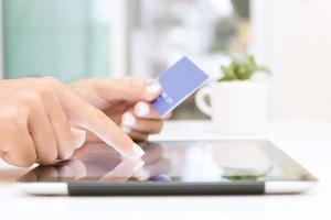 Closeup mano usando tableta y tarjeta de crédito de compras en línea foto