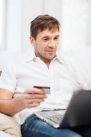 man with laptop and credit card at home