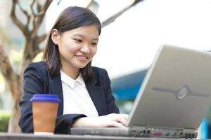 Young female Asian business executive using laptop