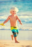 niño jugando en la playa foto