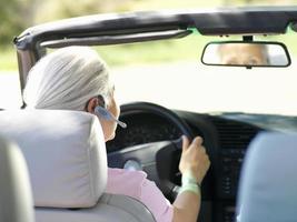 Mujer con dispositivo manos libres en coche, vista trasera