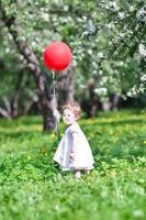 Funny baby girl playing with a big red balloon photo