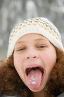 niña con nieve en la lengua foto
