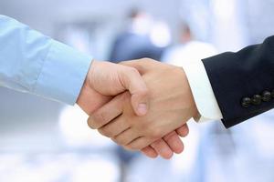 Image of a firm handshake  between two colleagues in office photo