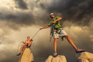 marido y mujer escalando equipo en la cumbre. foto