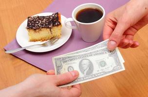 Paying for cheesecake and coffee in the cafe, finance concept
