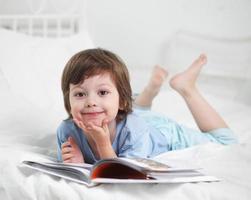 niño feliz lee el libro foto