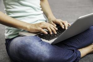 young woman sitting while using laptop photo