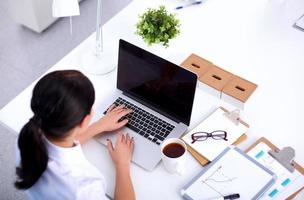 Portrait of a businesswoman sitting at  desk with  laptop photo