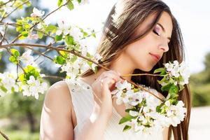 hermosa niña en un jardín de cerezos en flor foto