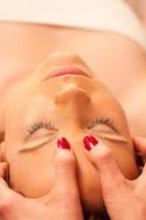 Woman having face massage treatment in wellness photo