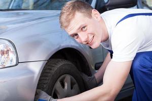 Auto mechanic checks a car tire photo