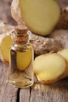 ginger oil in a glass bottle close-up, vertical photo