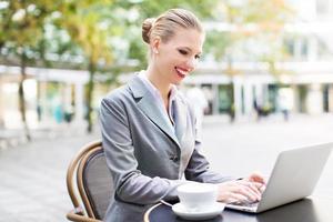 Businesswoman using laptop at cafe photo