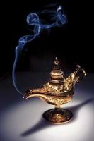 Magic Aladdin's Genie lamp on black with smoke photo