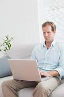 Casual man using laptop on the couch
