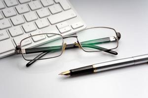 Glasses, pen and laptop