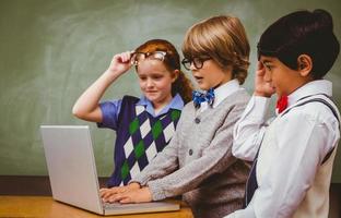 niños de la escuela usando una computadora portátil en el aula