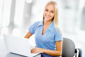 Portrait of young woman using laptop photo