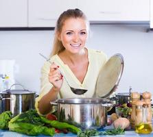 housewife cooking vegetables at domestic kitchen
